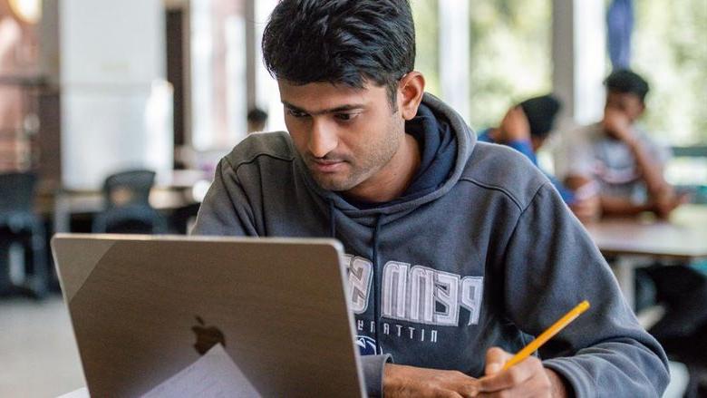 Student sitting at desk with laptop