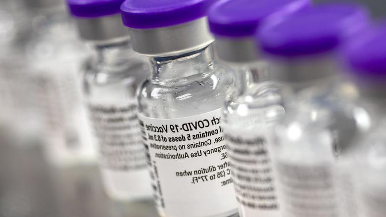 Glass vials with purple lids lined up side by side.